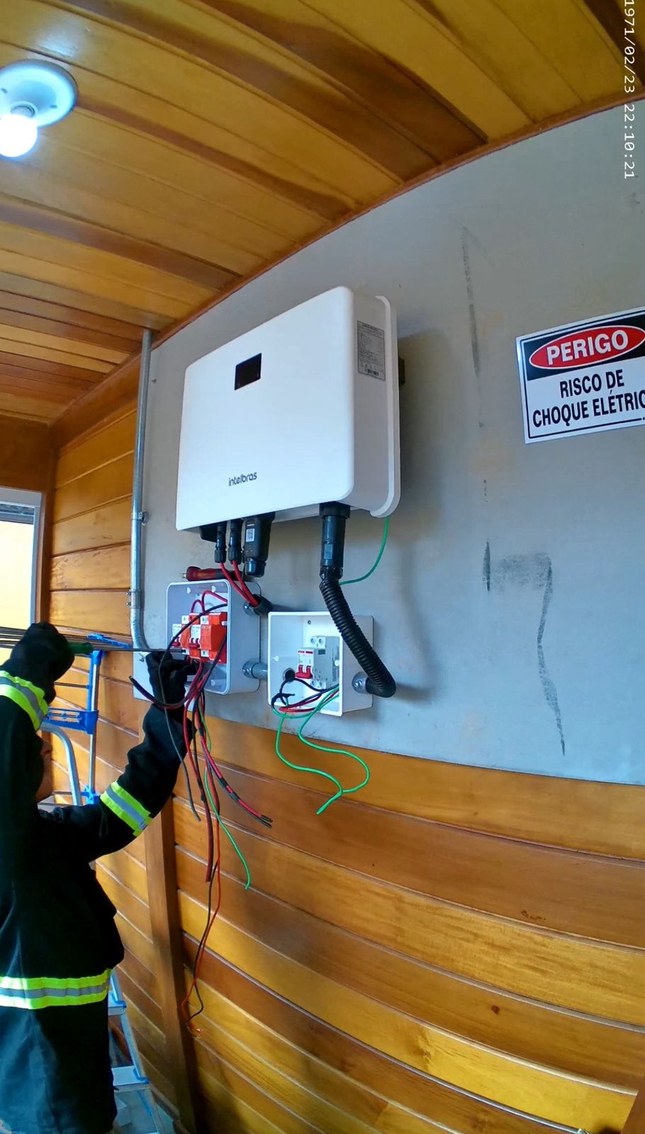 Técnico instalando inversor Intelbras para energia solar