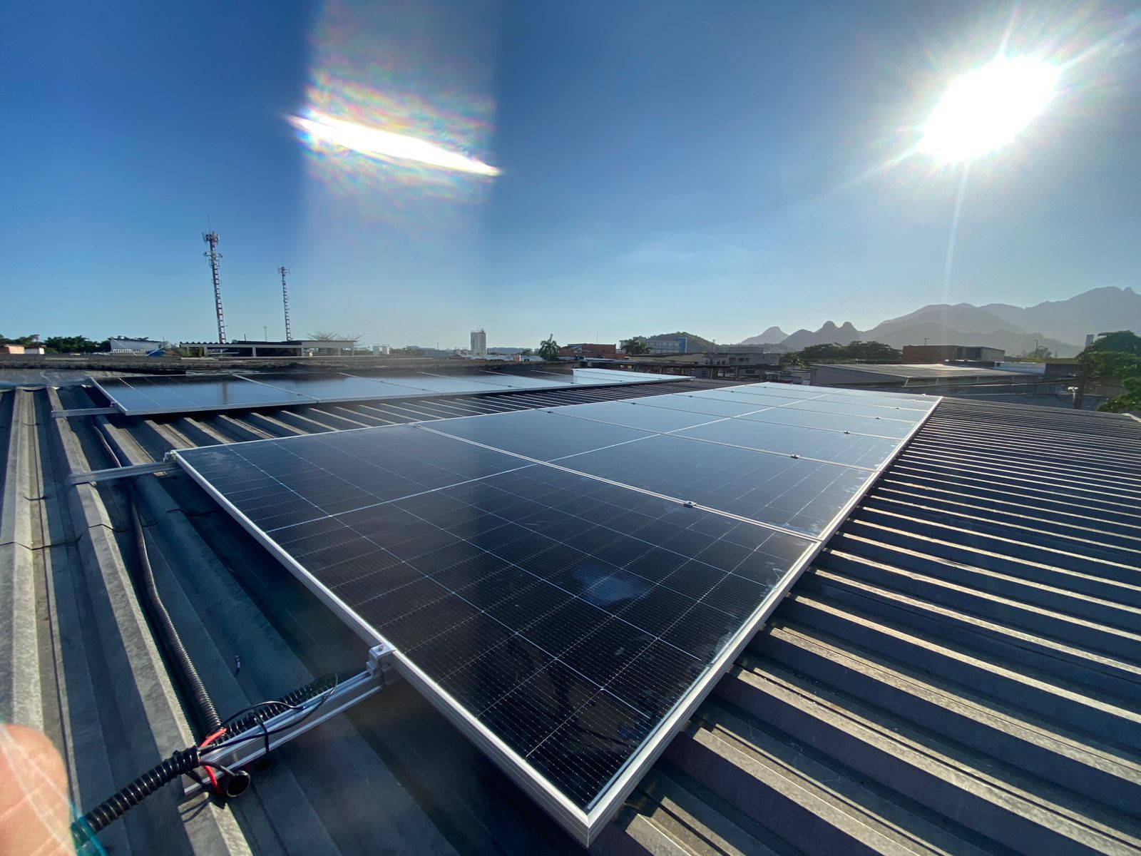 Painéis solares instalados em telhado comercial com vista panorâmica