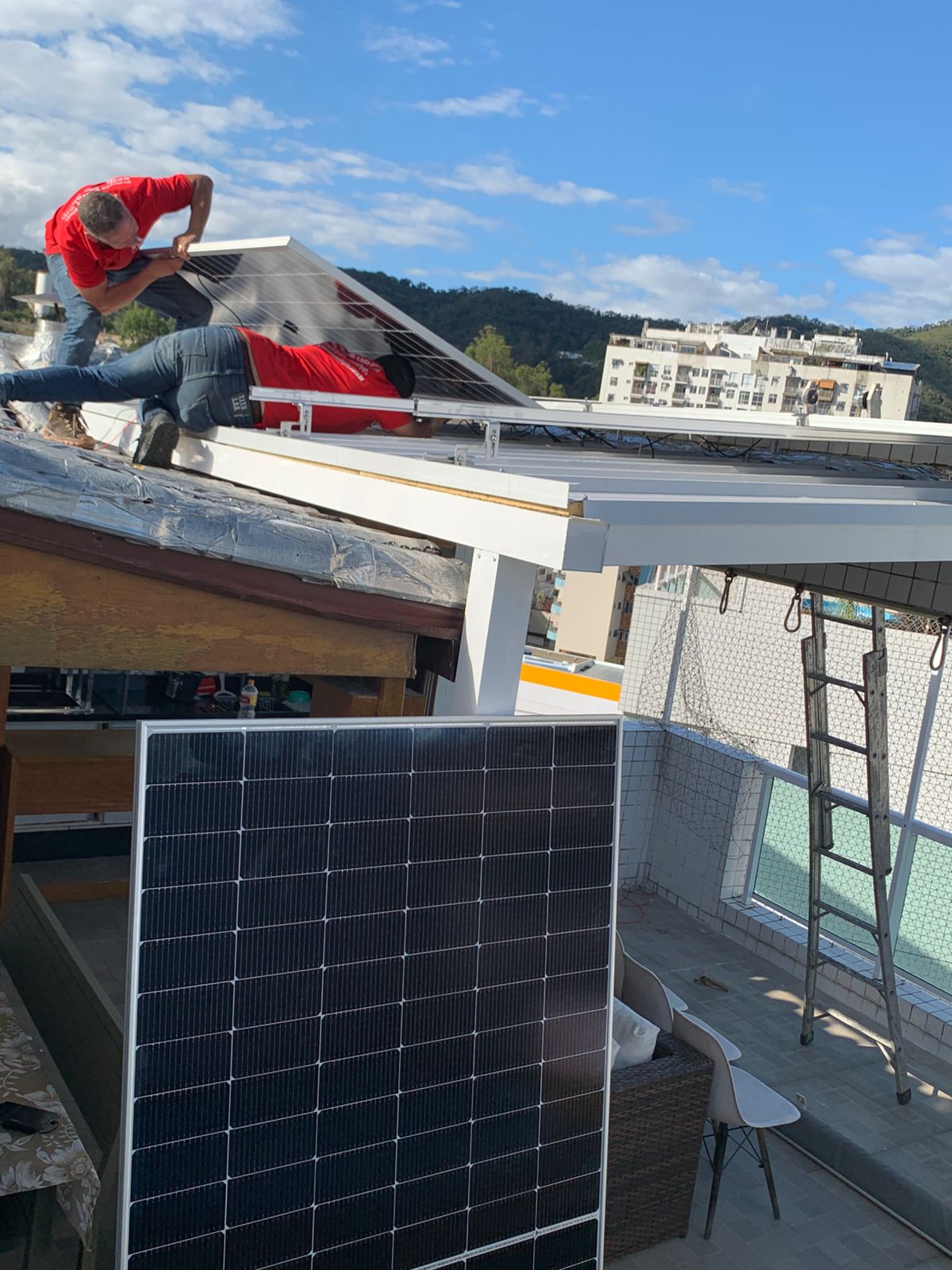 Técnicos instalando painéis solares em cobertura residencial